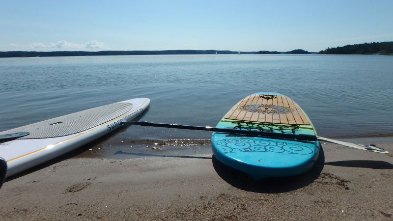 Stand up paddleboard i strandkanten.