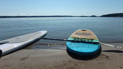 Stand up paddleboard i strandkanten.