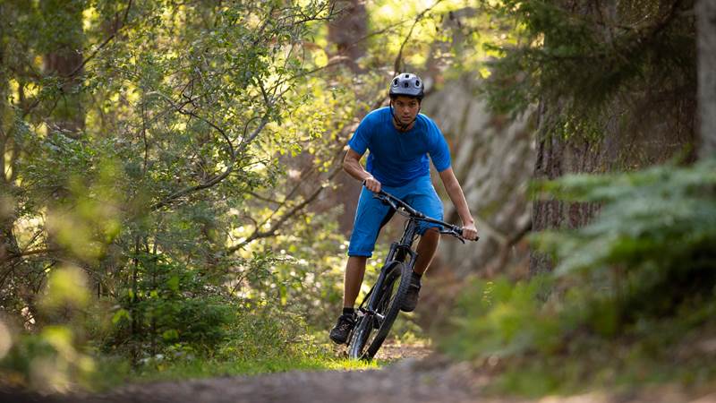 Man cyklar mountainbike i skogen