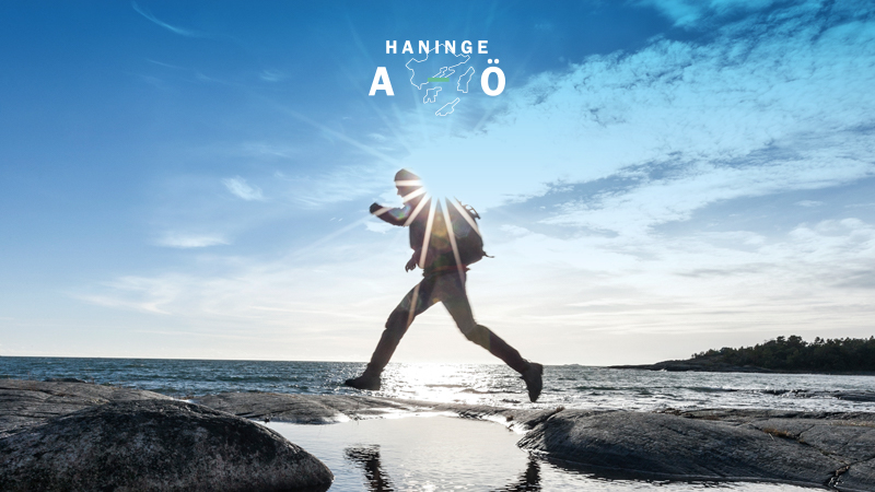 En man som hoppar från klippa till klippa ute på Utö.