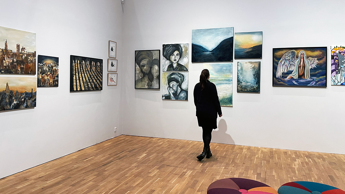 Kvinna står och tittar på konst.