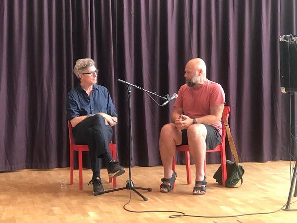 Henrik Andersson i samtal med Magnus Bärtås.  Två män samtalar på en scen.