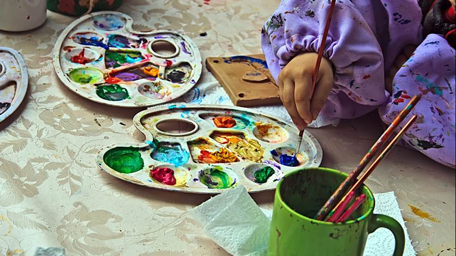 Ett barn målar med akrylfärg