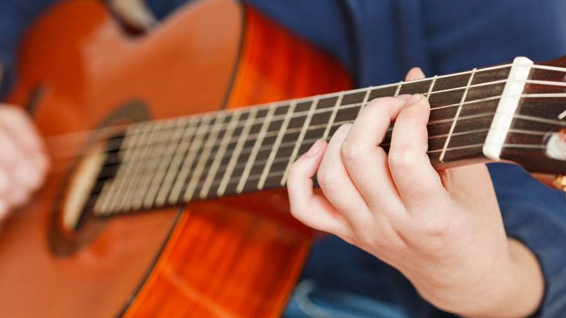 Hand spelar på gitarr.