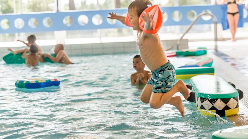 En pojke hoppar ner i en pool