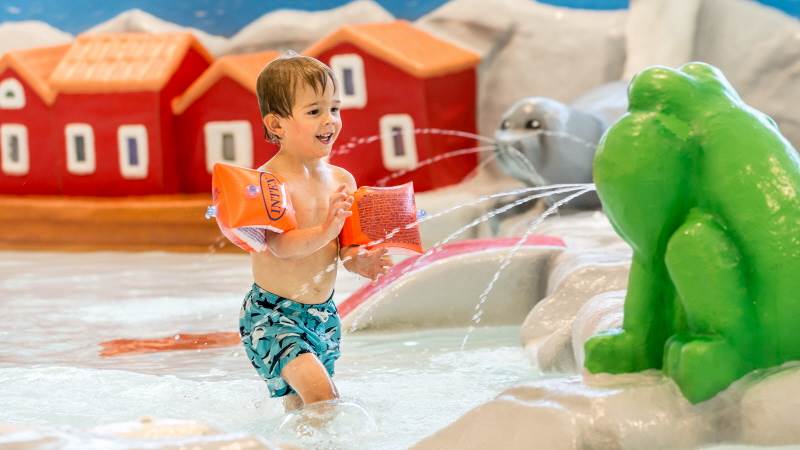 En pojke leker i en pool i Torvalla Simhall.