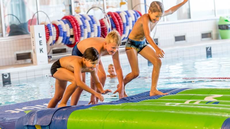 Pojkar hoppar i vattnet i Torvalla simhall