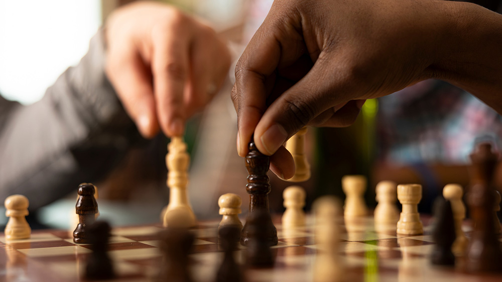 Händer som flyttar schackpjäser.